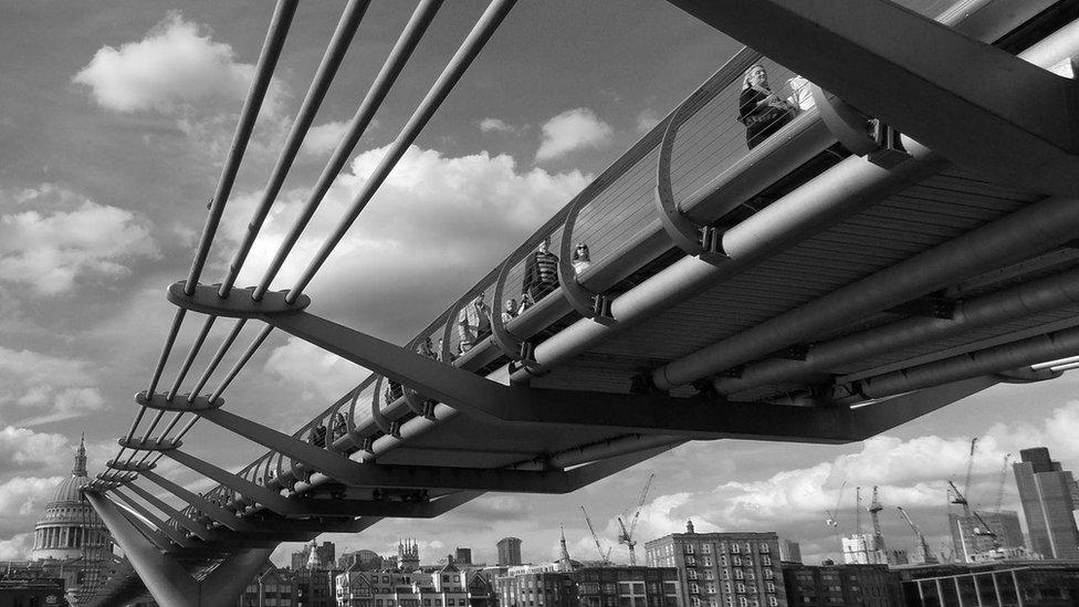 A black and white photograph of London's Millennium Bridge