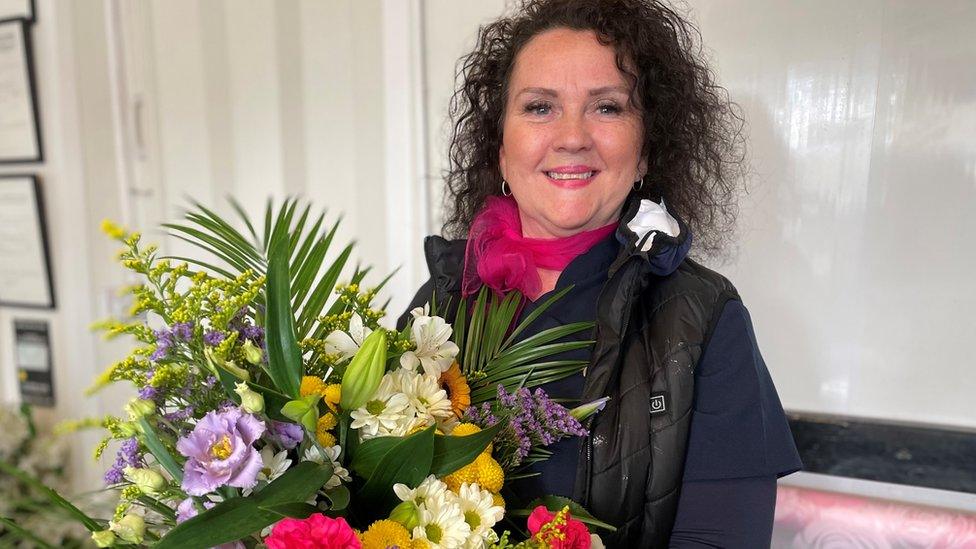 Kathryn Berbillion holding a bouquet of flowers