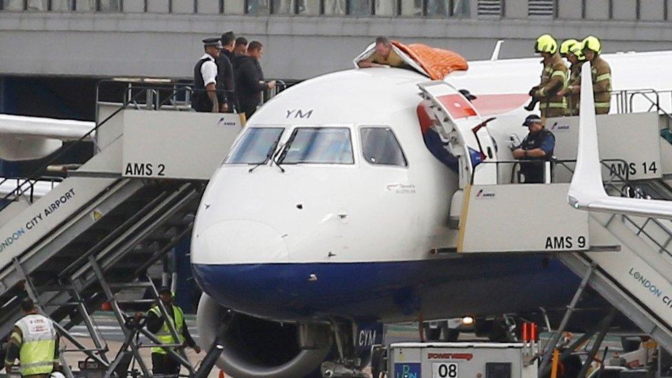 A man on top of plane at London City Airport