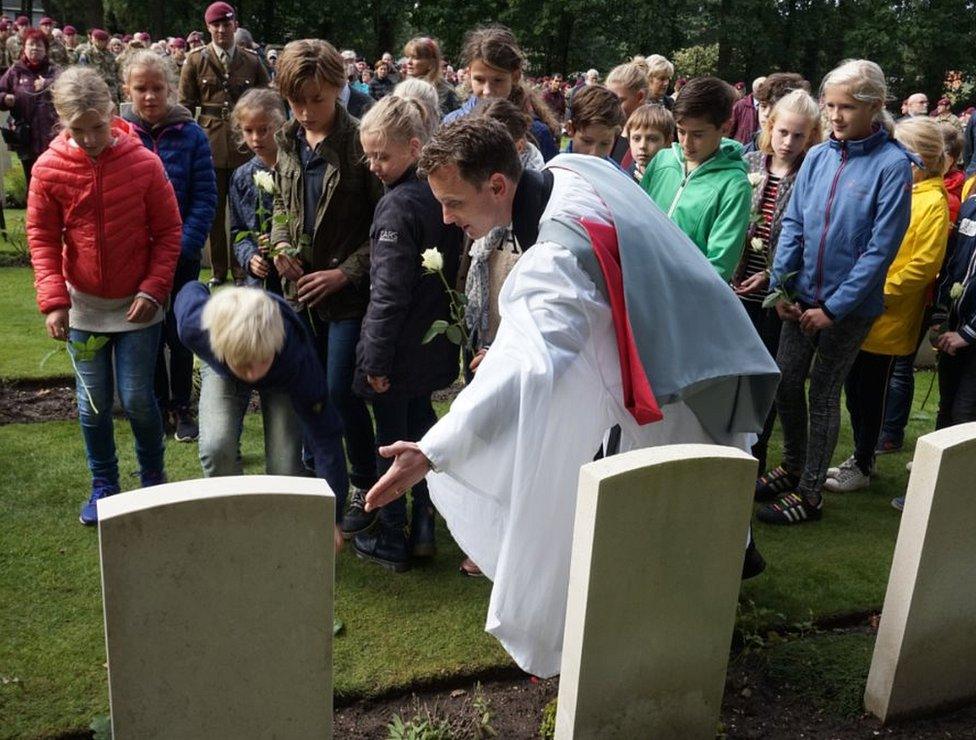 School children laying white roses