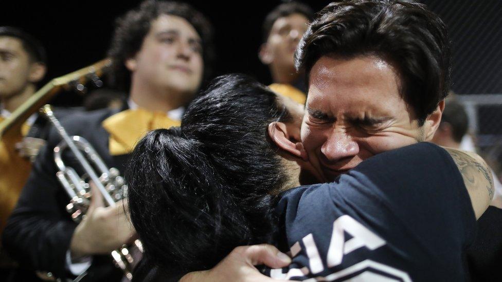 Man clutches woman during a vigil in El Paso