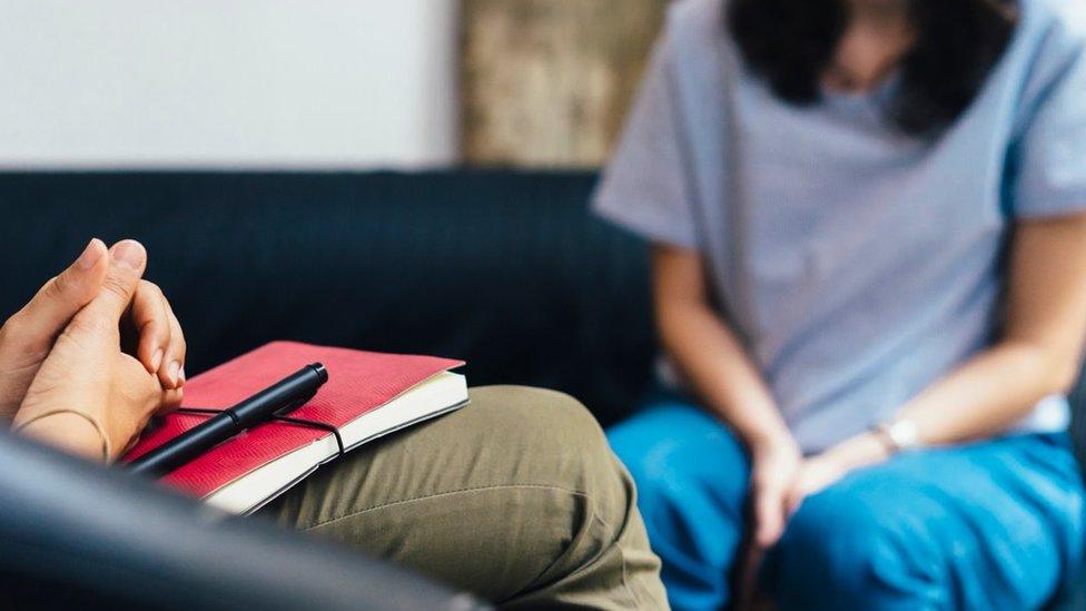 Woman sits with a mental health professional