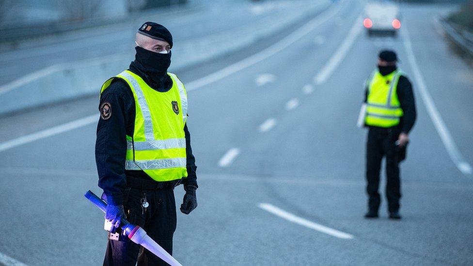 Catalan police officers stand guard outside Igualada, which is in lockdown