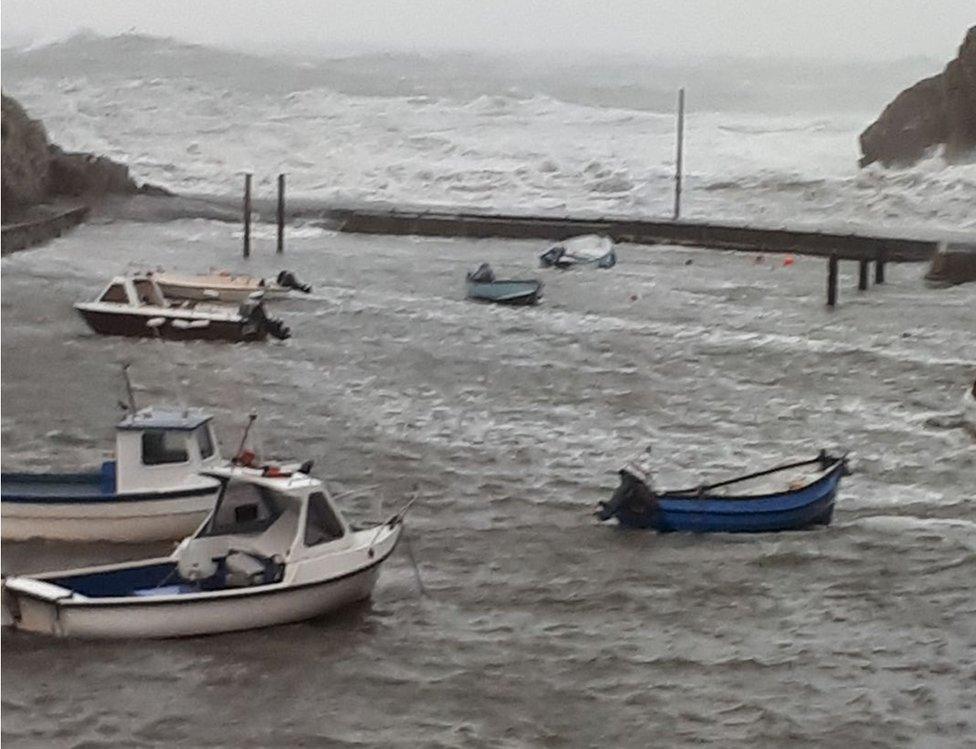 Cychod yn ymladd y tonnau ym mhorthladd Porthclais, ger Tyddewi