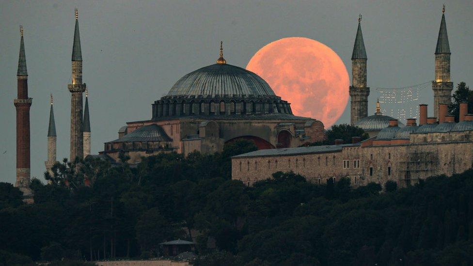 Full moon rises over the Hagia Sophia Grand Mosque and Blue Mosque in Istanbul in Turkey.