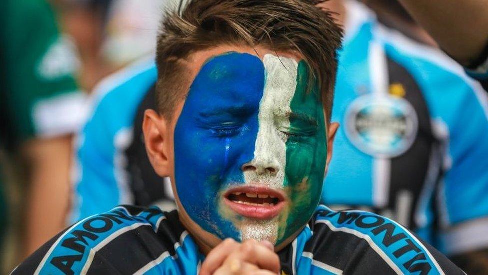 Fans of Gremio react during an homage for the Brazilian team Chapecoense Real victims of a plane crash in Colombia on November 29, ahead of the match between Atletico Mineiro and Gremio for the Copa do Brasil 2016 final at Mineirao stadium in Porto Alegre, Brazil, on December 7, 2016