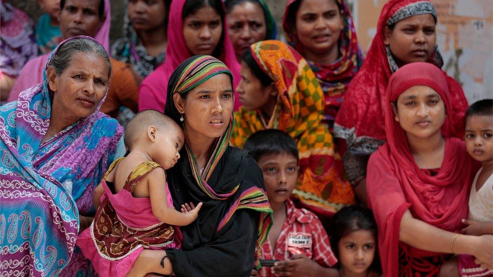 Locals gather outside a building where two people were killed by unidentified assailants in Dhaka, Bangladesh, Tuesday, April 26, 2016