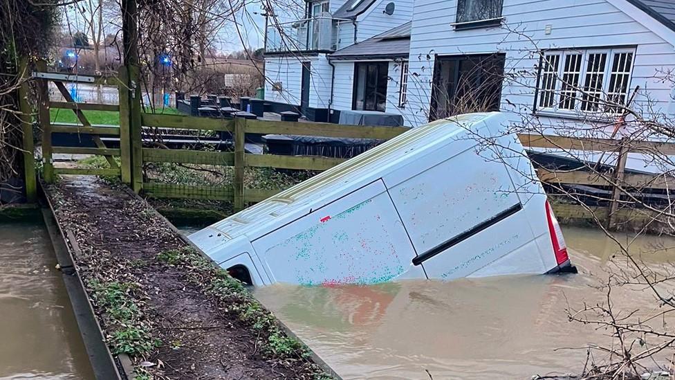 White van in flooded ford