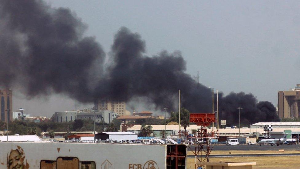 Heavy smoke billows above buildings in the vicinity of the Khartoum airport on April 15, 2023