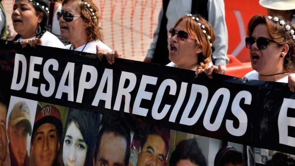 Mothers hold portraits of their missing sons during a march against the government in demand of the clarification of the disappeared in Mexico City on May 10, 2017