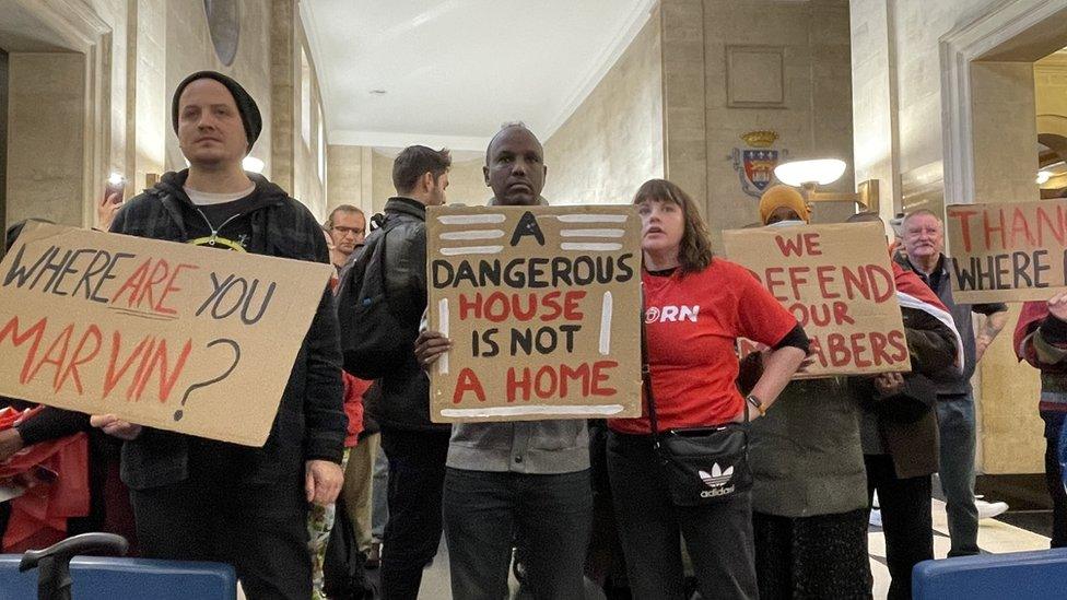 Residents holding placards inside City Hall in Bristol