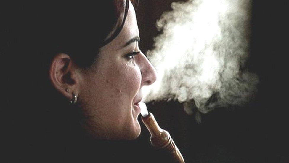 A woman smokes Shisha at a cafe in Dubai on May 31, 2008.