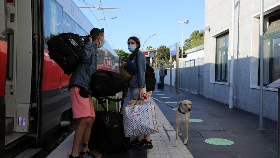 Passengers get off a train as restrictions between regions are eased