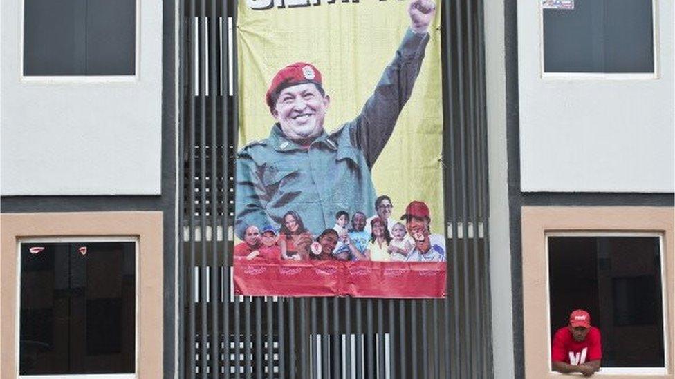 A man leans out of a window at his home received from Mision Vivienda, an economic programme of the Venezuelan government to provide housing for low-income people, in Ciudad Caribia, Caracas