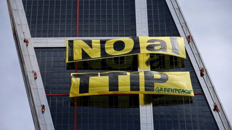 Greenpeace activists display a banner against TTIP free trade agreement while suspended on one of the Kio towers in Madrid, Spain