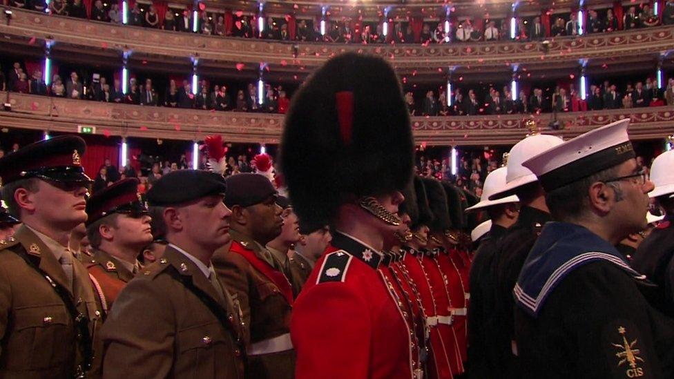 Poppies fell from the ceiling over members of the Royal Navy, the Army and Royal Air Force who stood in the centre of the hall