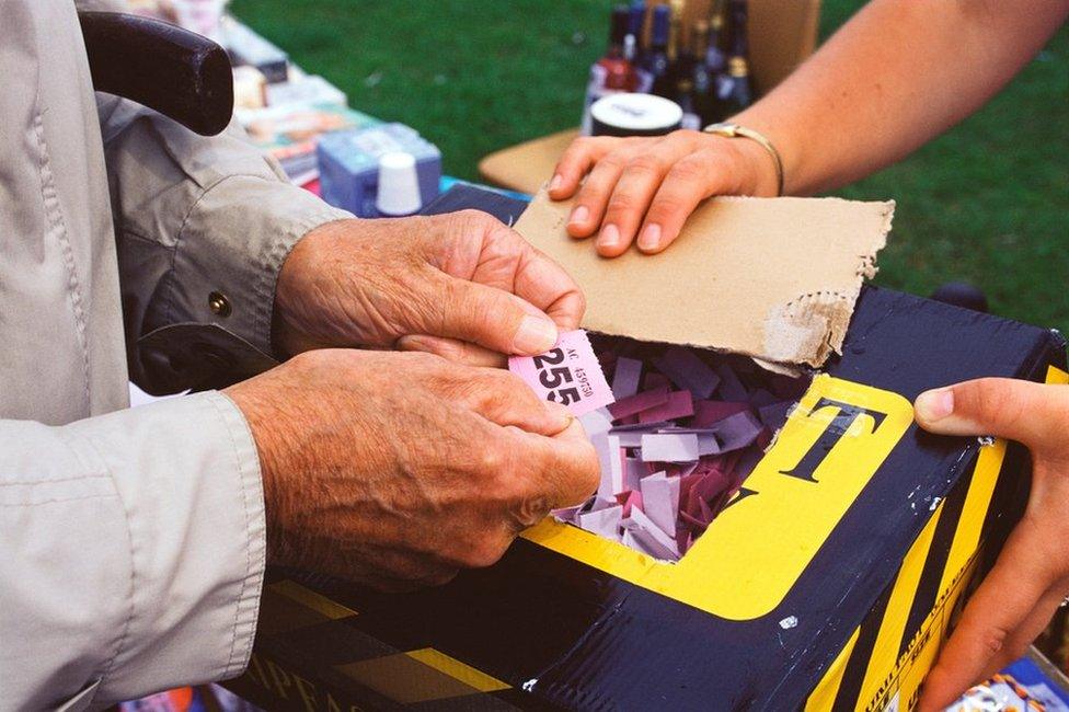 Man picking out raffle ticket