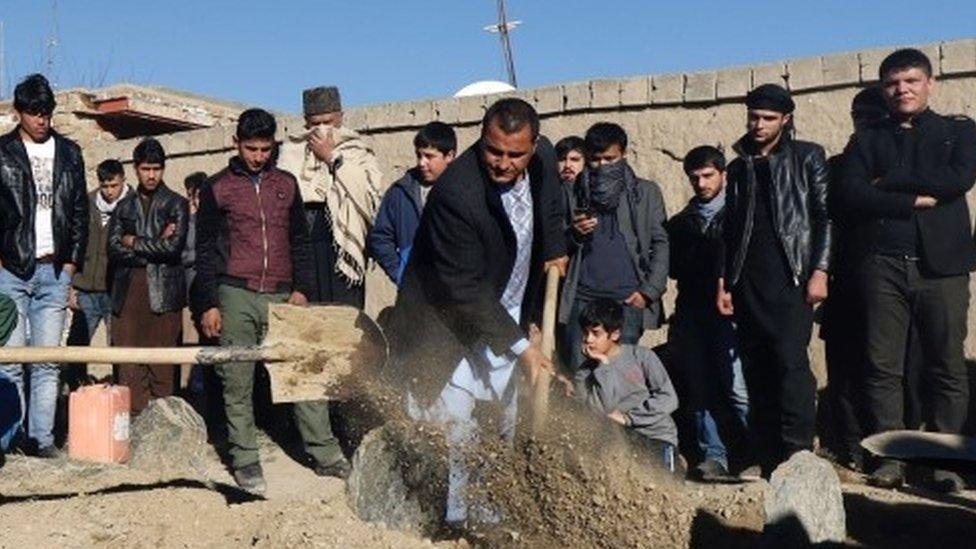 Mourners attend the burial of the victims of a suicide bomb attack in Kabul (21 January 2016)