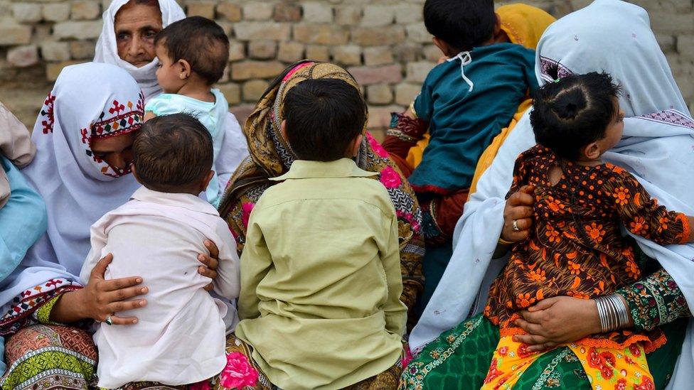 Parents nervously watch over their children as they jostle in line to be tested for HIV in a village near Pakistan's Larkana amid a sudden outbreak among its young