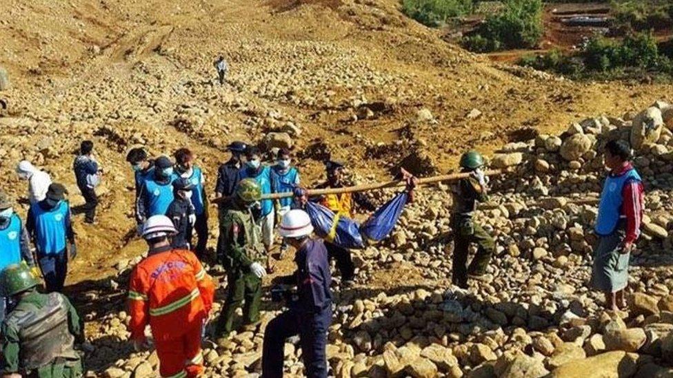 Soldiers carry the bodies of miners killed by a landslide in a jade mining area in Hpakhant, in Myanmar's Kachin state on November 22, 2015.