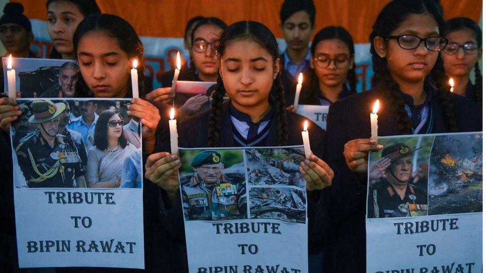 Students hold candles and posters to pay tribute to India's defense chief General Bipin Rawat, at their school in Amritsar on December 9, 2021