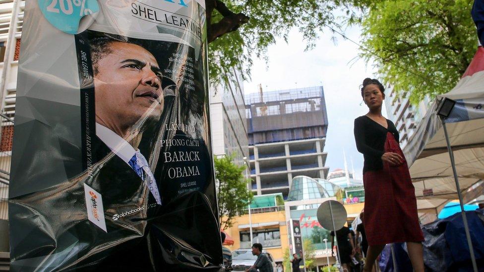 A woman walks past an advertisement picture of US President Barack Obama promoting the book "Leadership, the Barack Obama way" by Shel Leanne translated into Vietnamese outside a book store in Ho Chi Minh City, Vietnam, 22 May 2016