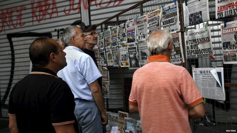 People read newspaper headlines in Athens on 27 June