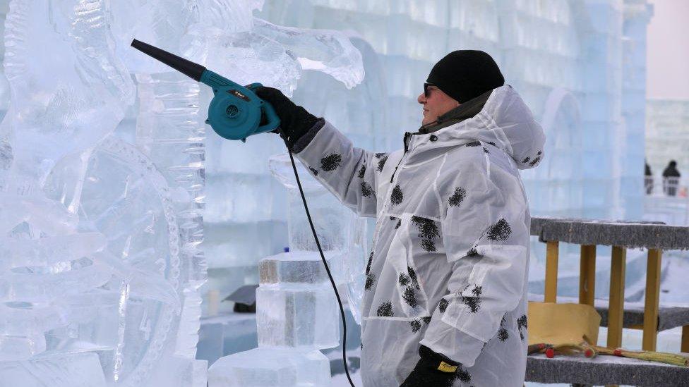 man heating up ice sculpture to shape