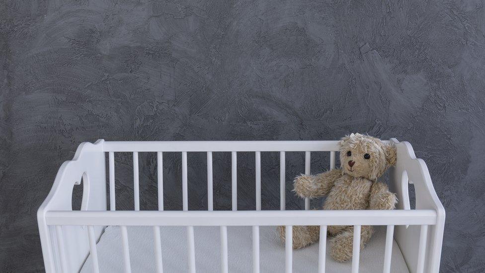 Cot with teddy bear inside