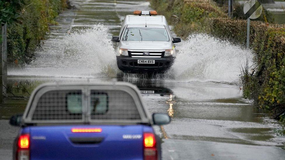 Cars drive through flood water