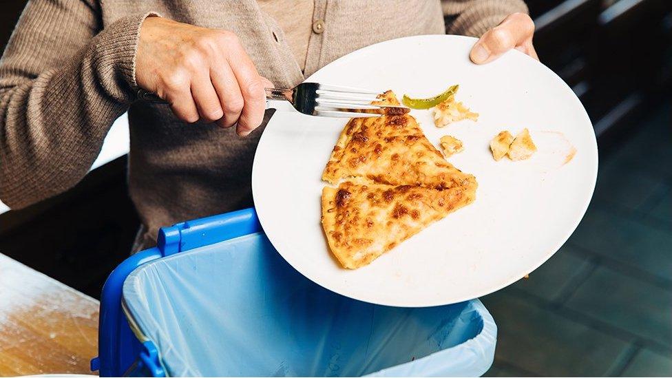 Food being scraped into waste bin