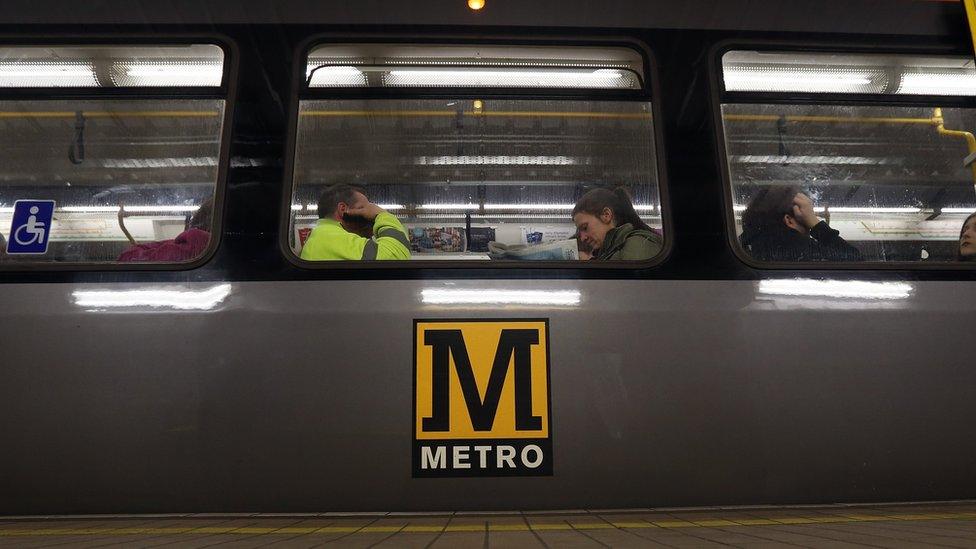 Man and woman sit on Metro carriage