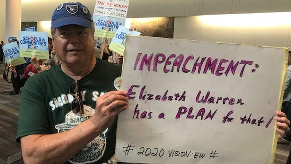 Ted Smith holds an impeachment sign at the California State Democratic Convention.