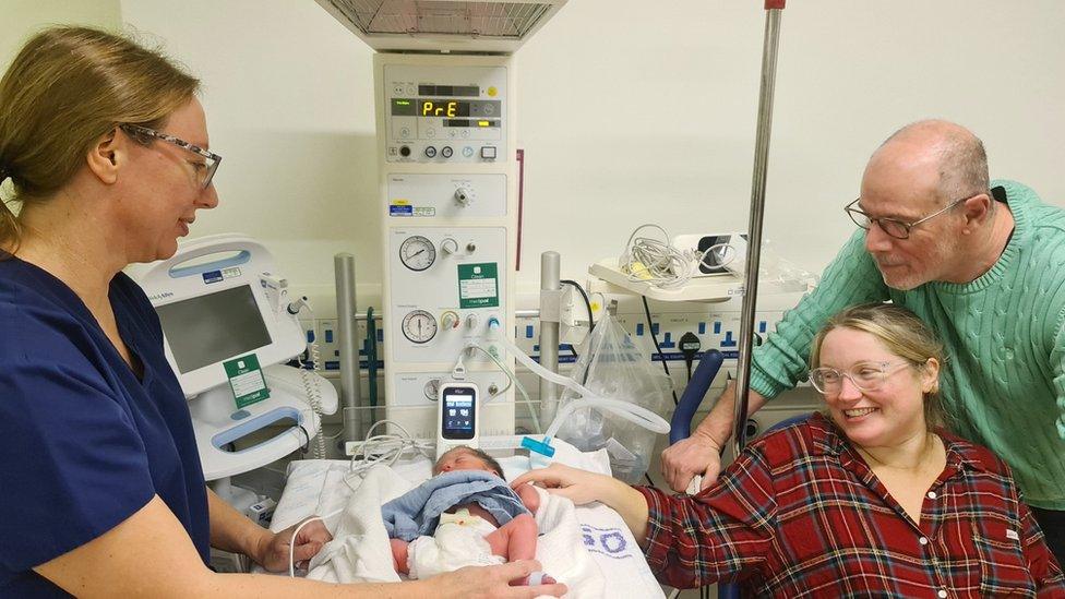 Baby George undergoing the screening with his parents