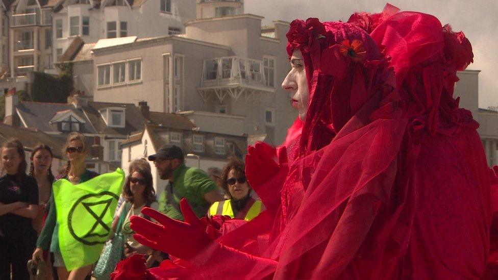 Protesters on the beach wearing red robes