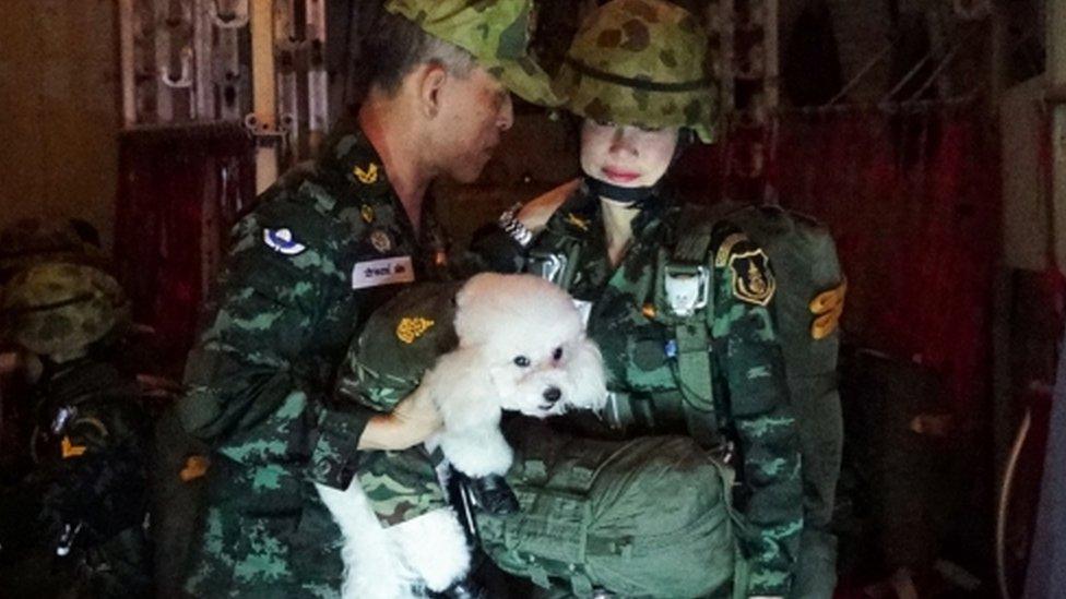 Thai King Maha Vajiralongkorn (L) holding a poodle next to royal consort Sineenat Wongvajirapakdi (R)