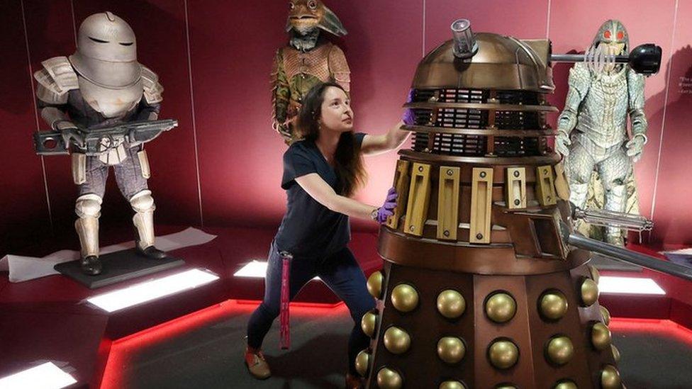 Head of museum exhibitions Catherine Johnson moves a replica of a Dalek in an exhibition