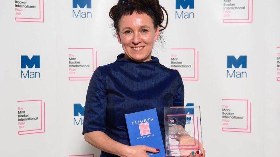 Polish author Olga Tokarczuk stands with her novel and her International Man Booker prize.