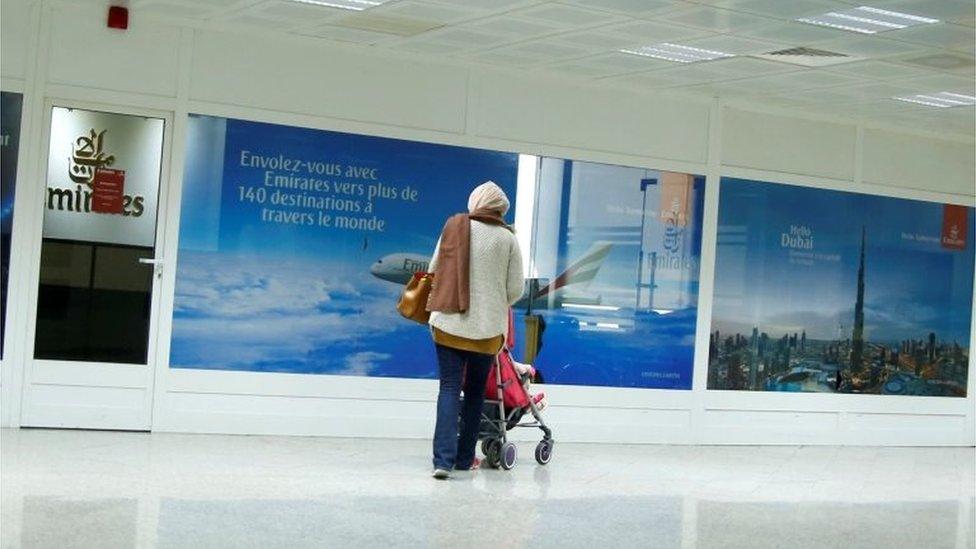 A women are seen in front of the Dubai airline Emirates office, at Tunis-Carthage International Airport in Tunis, Tunisia, December 25, 2017