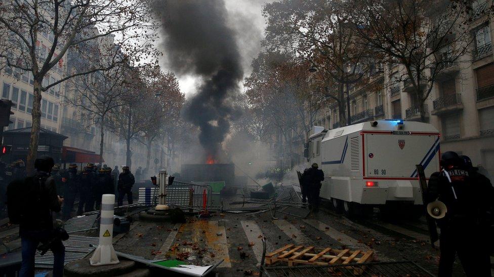 rench riot police stand guard near a barricade during clashes with protesters wearing yellow vests, a symbol of a French drivers" protest against higher diesel taxes, at the Place de l"Etoile in Paris, France, December 1, 2018