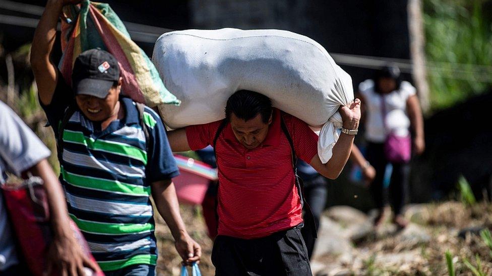 People walk after having crossed illegally the Suchiate river from El Carmen in Guatemala to Talisman in Chiapas State, Mexico, on June 7, 2019