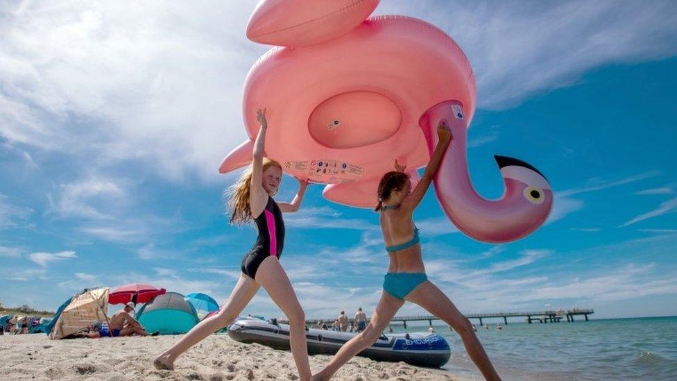 Two girls carry an inflated flaming at the beach of Rerik at the Baltic Sea, northeastern German