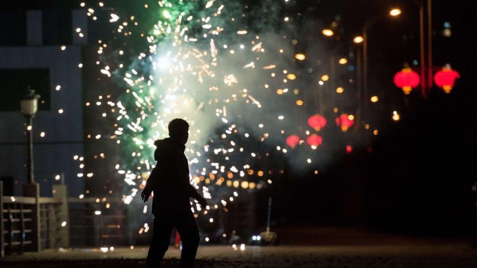 A man sets off fireworks to celebrate the Lunar New Year near the Yalu River in the Chinese border town of Dandong opposite the North Korean town of Sinuiju on February 7, 2016