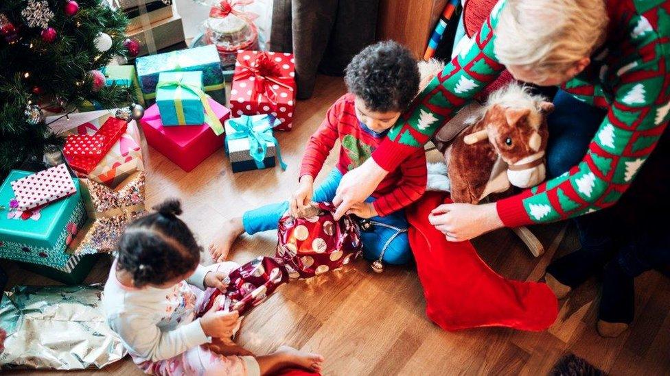 Grandfather and kids open presents