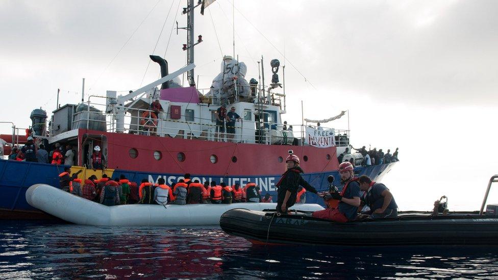 Migrants on an inflatable boat boarding the Lifeline sea rescue boat at sea on June 21, 2018