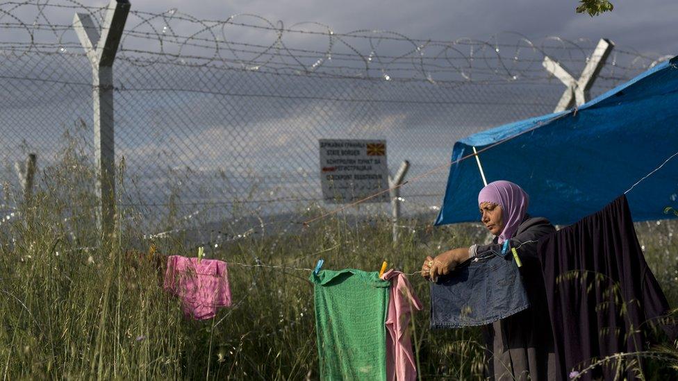 Woman hangs laundry near Greece-Macedonia border fence - 15 May