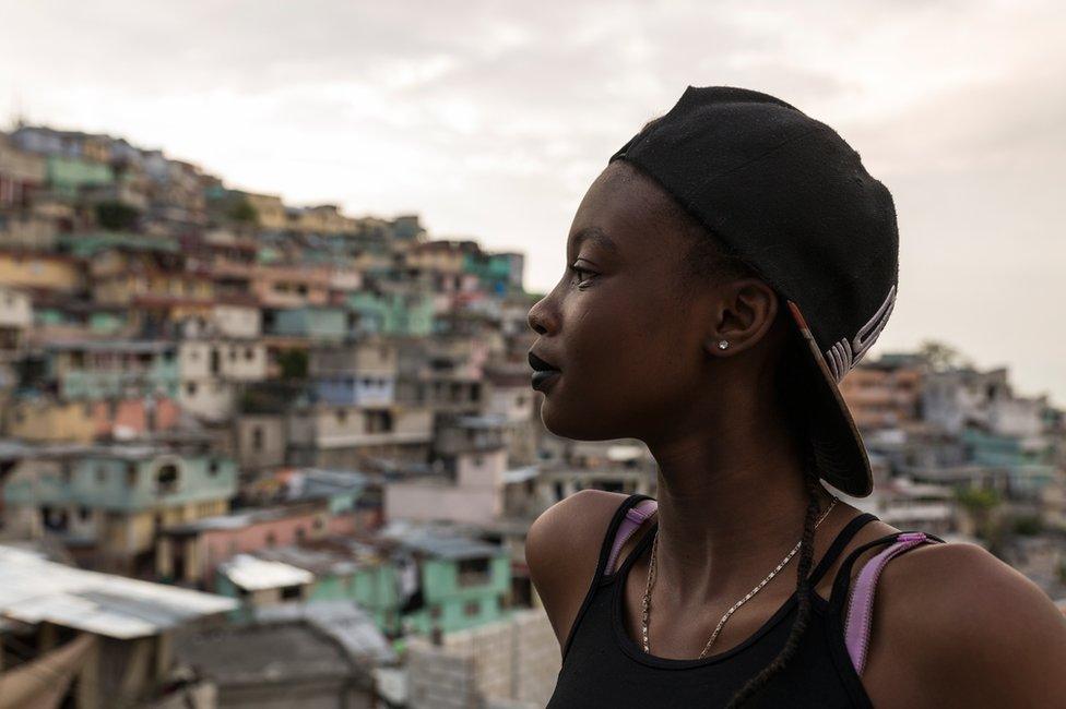 Ckimy, 16, looks out from a rooftop onto the colourfully painted houses of Jalousie