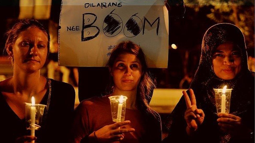 Foreign tourists take part in a prayer for explosion victims at Jakarta this morning on January 14, 2016 in Surabaya, Indonesia.