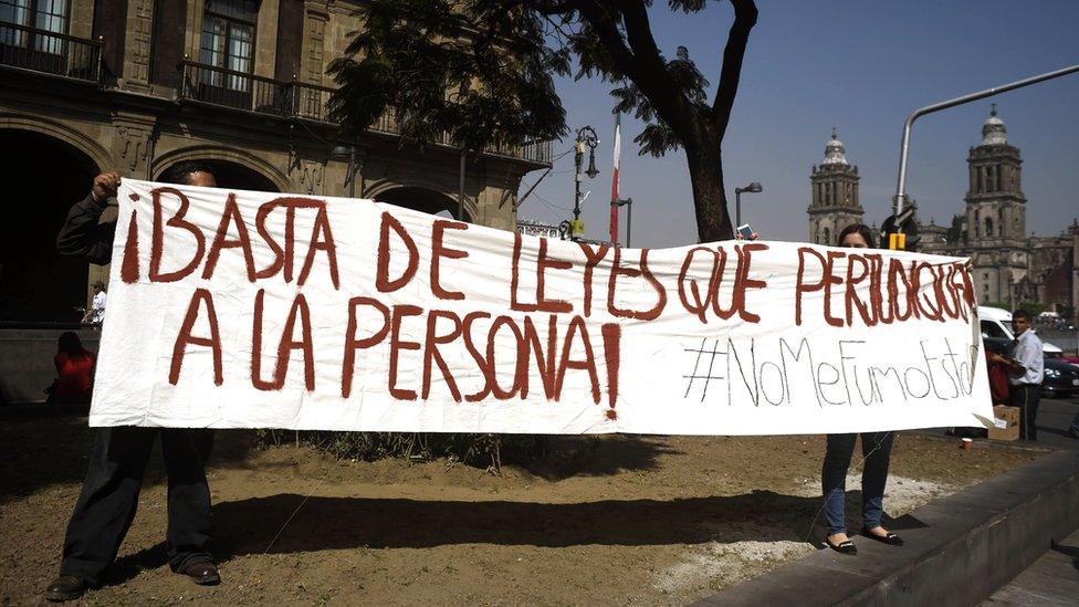 Demonstrators holding banner saying "Enough of laws which are detrimental to people"