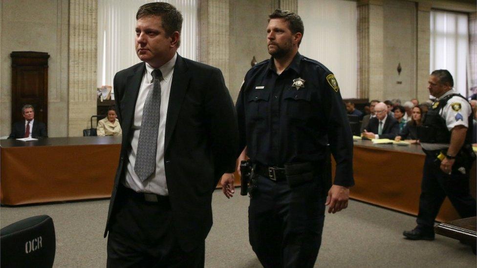 Chicago police Officer Jason Van Dyke, left, is lead away in handcuffs after his guilty verdict